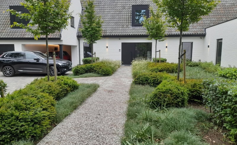 Duurzaam tuinontwerp met groene planten en een grindpad voor eco-vriendelijke woning.
