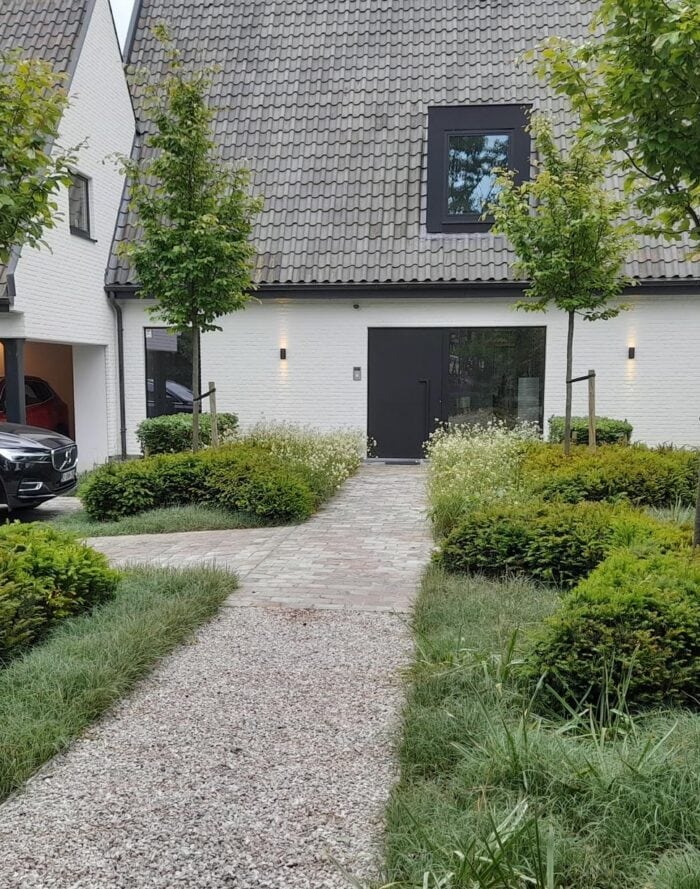 Moderne woning met groene tuin en wandelpad, eco-vriendelijk ontwerp.